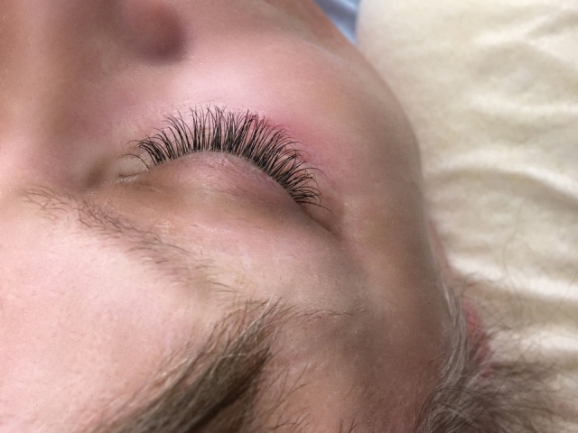 Left eye. Classic eyelash extensions. Closed eyelid. Top view.